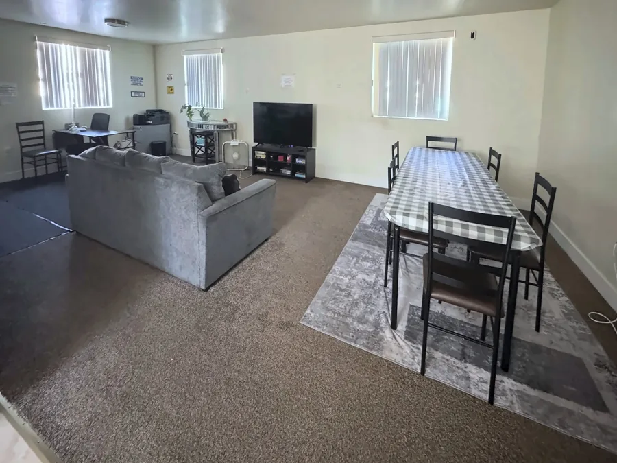 Common room with a sofa, a television and a dining table